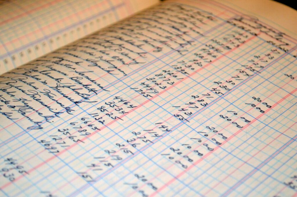 Про нас Close-up of a vintage handwritten ledger detailing financial records and accounts.